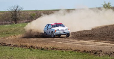 ODESSA, UKRAINE - 30 Nisan 2017: Geleneksel ralli Autocross Şampiyonası. Yarış arabası tehlikeli. Dik bir yarış pistine giriyor, etrafa saçılıyor, toz püskürtüyor. Aşırı ralli otomobili
