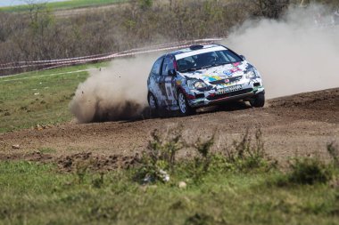 ODESSA, UKRAINE - 30 Nisan 2017: Geleneksel ralli Autocross Şampiyonası. Yarış arabası tehlikeli. Dik bir yarış pistine giriyor, etrafa saçılıyor, toz püskürtüyor. Aşırı ralli otomobili