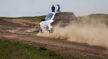 ODESSA, UKRAINE - 30 Nisan 2017: Geleneksel ralli Autocross Şampiyonası. Yarış arabası tehlikeli. Dik bir yarış pistine giriyor, etrafa saçılıyor, toz püskürtüyor. Aşırı ralli otomobili