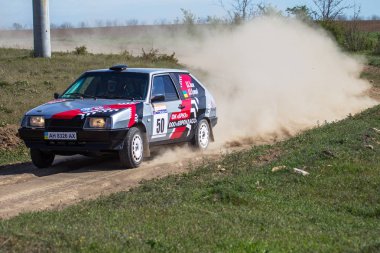 ODESSA, UKRAINE - 30 Nisan 2017: Geleneksel ralli Autocross Şampiyonası. Yarış arabası tehlikeli. Dik bir yarış pistine giriyor, etrafa saçılıyor, toz püskürtüyor. Aşırı ralli otomobili