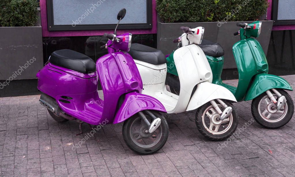 Motorcycles for pizza delivery, parked on the street, waiting for the order and delivery to the client. Mobile fast delivery of fresh hot pizza in the business part of the city