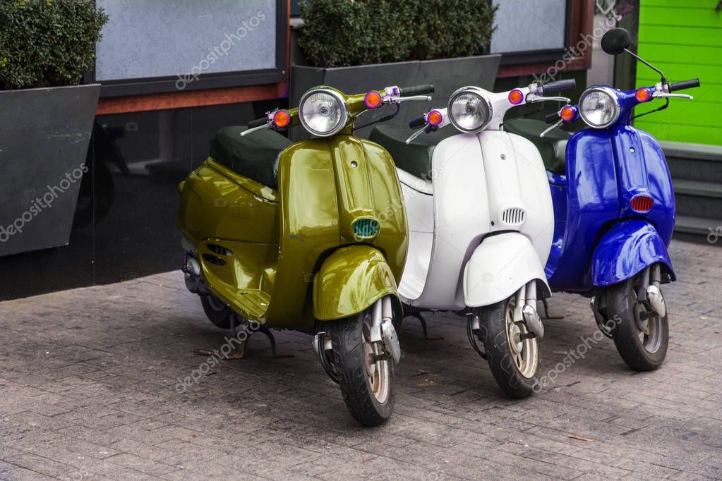 Motorcycles for pizza delivery, parked on the street, waiting for the order and delivery to the client. Mobile fast delivery of fresh hot pizza in the business part of the city