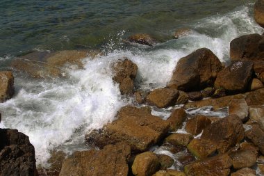 Güzel deniz dalgaları kayalık sahil buzlu ayrılır. Aydınlık yatay görüntüleme biçimi reklam yaz seyahat, geri kalanı için bir arka plan üzerinde deniz, okyanus. Kayanın üzerinde çökmesini dalgalar deniz manzaralı