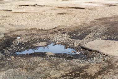 Çok kötü asfalt yol. Asfalttaki çatlaklar, çukurlar. Düşük kalitede bir yamadan sonra yerel asfalt yolunun durumu çok kötü