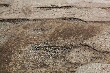 Çok kötü asfalt yol. Asfalttaki çatlaklar, çukurlar. Düşük kalitede bir yamadan sonra yerel asfalt yolunun durumu çok kötü