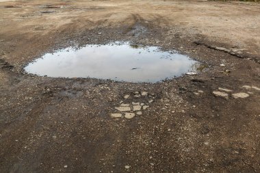 Çok kötü asfalt yol. Asfalttaki çatlaklar, çukurlar. Düşük kalitede bir yamadan sonra yerel asfalt yolunun durumu çok kötü
