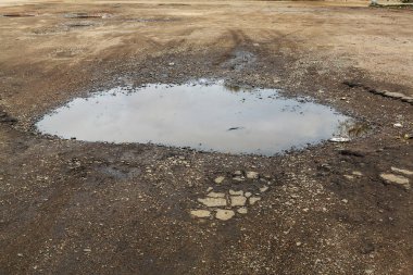 Çok kötü asfalt yol. Asfalttaki çatlaklar, çukurlar. Düşük kalitede bir yamadan sonra yerel asfalt yolunun durumu çok kötü