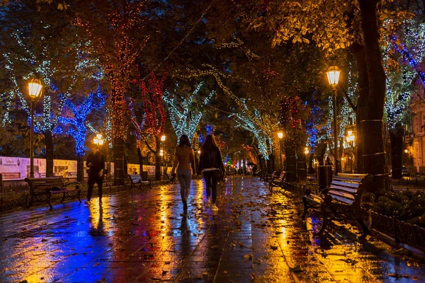 晚雨后的城市的古老中心 夜都市街道与明亮的颜色的街道咖啡馆和移动的汽车的光 — 图库照片