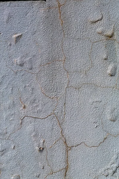 Beautiful old wall with large cracks texture. Spider web cracks in texture of old painted plaster walls. Concrete wall with cement, plaster and cracks in construction industry. Background for your design
