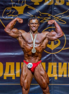 Odessa, Ukrayna -23 Ekim 2016: sporcular erkekler vücut geliştirme ve fitness kategori fitness ve vücut geliştirme modeli üzerinde Şampiyonası Ukrayna katılmak. Sahne Alanı'nda büyük kas erkeklerle güzel atletik rakam