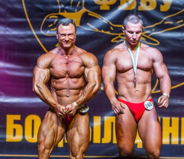 Odessa, Ukrayna -23 Ekim 2016: sporcular erkekler vücut geliştirme ve fitness kategori fitness ve vücut geliştirme modeli üzerinde Şampiyonası Ukrayna katılmak. Sahne Alanı'nda büyük kas erkeklerle güzel atletik rakam