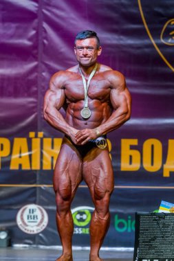 Odessa, Ukrayna -23 Ekim 2016: sporcular erkekler vücut geliştirme ve fitness kategori fitness ve vücut geliştirme modeli üzerinde Şampiyonası Ukrayna katılmak. Sahne Alanı'nda büyük kas erkeklerle güzel atletik rakam