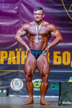 Odessa, Ukrayna -23 Ekim 2016: sporcular erkekler vücut geliştirme ve fitness kategori fitness ve vücut geliştirme modeli üzerinde Şampiyonası Ukrayna katılmak. Sahne Alanı'nda büyük kas erkeklerle güzel atletik rakam