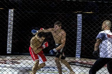 Odessa, Ukrayna - 13 Aralık: Atletizm Mma, karışık dövüş sanatları savaşçı hücrede rekabet neden yumruk atıyor ve başladı. Dramatik an savaş, 13 Aralık 2014 Odessa, Ukrayna