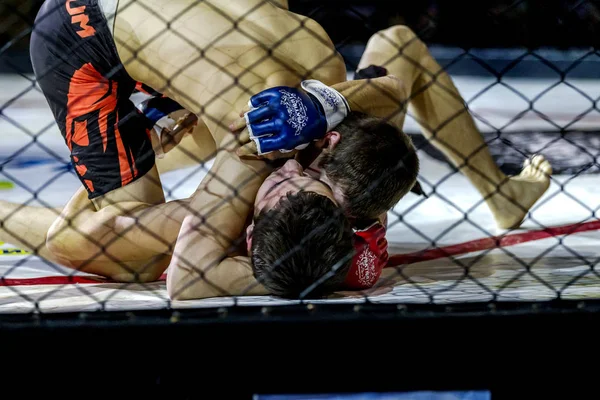 Odessa, Ukrayna - 13 Aralık: Atletizm Mma, karışık dövüş sanatları savaşçı hücrede rekabet neden yumruk atıyor ve başladı. Dramatik an savaş, 13 Aralık 2014 Odessa, Ukrayna