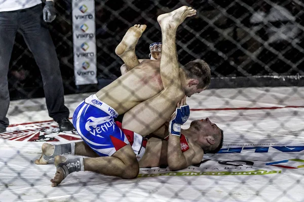 Odessa, Ukrayna - 13 Aralık: Atletizm Mma, karışık dövüş sanatları savaşçı hücrede rekabet neden yumruk atıyor ve başladı. Dramatik an savaş, 13 Aralık 2014 Odessa, Ukrayna