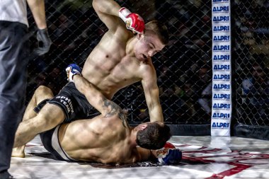 Odessa, Ukrayna - 13 Aralık: Atletizm Mma, karışık dövüş sanatları savaşçı hücrede rekabet neden yumruk atıyor ve başladı. Dramatik an savaş, 13 Aralık 2014 Odessa, Ukrayna