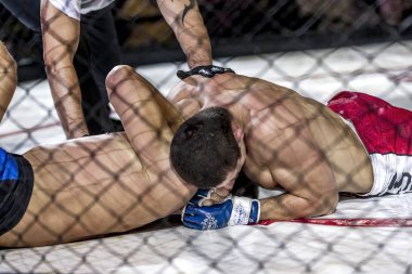 Odessa, Ukrayna - 13 Aralık: Atletizm Mma, karışık dövüş sanatları savaşçı hücrede rekabet neden yumruk atıyor ve başladı. Dramatik an savaş, 13 Aralık 2014 Odessa, Ukrayna