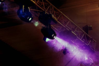 Sahne ışıkları. Arka planda gösteri. Karanlıkta ışık spot. Tiyatro sahne iç projektör ile aydınlatılır. Sahne ışıkları ve konser sırasında duman sahne. Rampa karanlıkta çeşitli projektörler