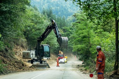 Rila Manastırı, Bulgaristan - 30 Temmuz 2016: dağ yolu genişletmek için inşaatı işi. Modern yol yapım ekipmanları çalışır. Dar geçit. Kapalı yol. Karayolu onarım çalışmaları