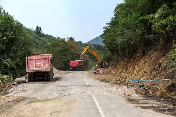 Rila Manastırı, Bulgaristan - 30 Temmuz 2016: dağ yolu genişletmek için inşaatı işi. Modern yol yapım ekipmanları çalışır. Dar geçit. Kapalı yol. Karayolu onarım çalışmaları