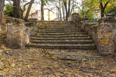 Eski taş merdivenle yukarı ve aşağı dokulu arka plan zarar görmüş. Eski taş merdiven çatlaklar şehir parkında çimento
