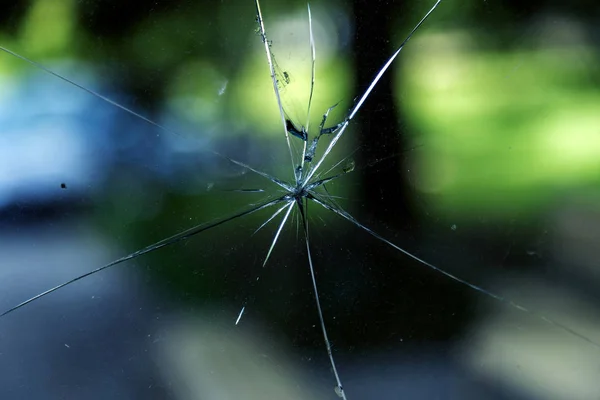 Abstract background of cobweb cracks Broken glass. The texture of the broken glass cracks. Close-up of a cracked glass. Dirty scratched broken glass of a glass office door