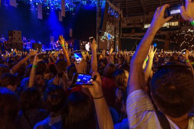 Odessa, Ukrayna - 25 Haziran 2016: Büyük kalabalık, yaratıcı ışık ve müzik gösterisi sırasında rock konseri. Kalabalık ve sıralar yüz-kontrolü, seyirci standları ve alan kişi. İnsanlar rahatlatıcı ve having fun