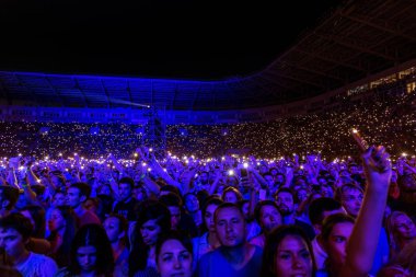Odessa, Ukrayna - 25 Haziran 2016: Büyük kalabalık, yaratıcı ışık ve müzik gösterisi sırasında rock konseri. Kalabalık ve sıralar yüz-kontrolü, seyirci standları ve alan kişi. İnsanlar rahatlatıcı ve having fun
