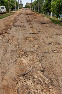 Dondurma ve çözme kışın döngüsü nedeniyle çukurlar ile bozuk asfalt yol. Kötü yol.