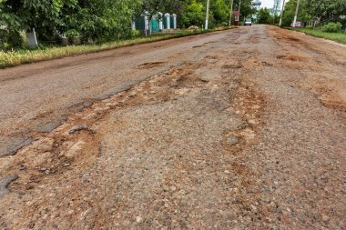 Dondurma ve çözme kışın döngüsü nedeniyle çukurlar ile bozuk asfalt yol. Kötü yol.