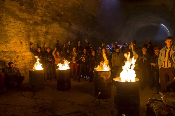 Odessa, Ukraine - November 22: Local rock band plays rock concert in the underground catacombs dungeon destroyed building. A crowd of happy people, fans around the campfire enjoy, November 22, 2014 in Odessa, Ukraine ..