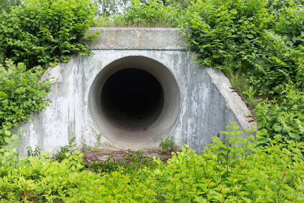 Large tunnel cement pipe as channel for sewage storm water. dark cave, tunnel. City tunnel. Round tunnel. Tunnel cement pipe has black shadow
