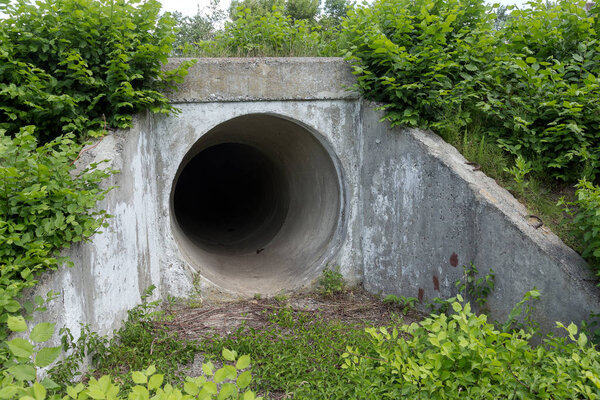 Large tunnel cement pipe as channel for sewage storm water. dark cave, tunnel. City tunnel. Round tunnel. Tunnel cement pipe has black shadow
