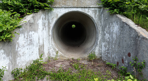 Large tunnel cement pipe as channel for sewage storm water. dark cave, tunnel. City tunnel. Round tunnel. Tunnel cement pipe has black shadow