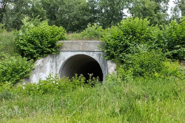 Large tunnel cement pipe as channel for sewage storm water. dark cave, tunnel. City tunnel. Round tunnel. Tunnel cement pipe has black shadow