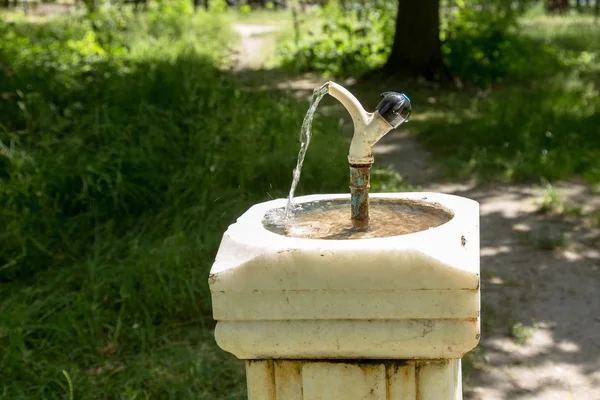 城市公园的一个古老的大理石柱上的饮用水城市喷泉 城市碗喝的人 水从水龙头 喷泉流出 供公园里的人喝水 — 图库照片
