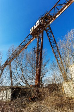Eski paslı terk edilmiş binada portal vinç paslı raylar üzerinde. Terk edilmiş konteyner yükleme boşaltma inşaat ambar. Ölü Zona. Mezarlık Çernobil, Pripyat, Ukrayna mühendislik; Bölge nükleer felaket
