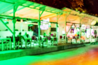 Küçük bir restoranın içi bulanık bir arka plan. Bokeh Kafe 'nin içini sıcak koyu renklerle bulanıklaştırmış. Yaratıcı moda tasarımı için arka plan olarak. Restoran, kafeterya arka planı çok güzel bulanık.