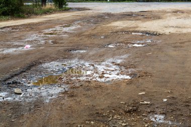 Çok kötü asfalt yol. Asfalttaki çatlaklar, çukurlar. Düşük kalitede bir yamadan sonra yerel asfalt yolunun durumu çok kötü