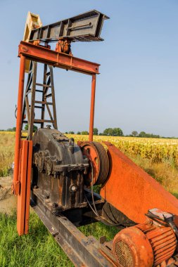 Küçük özel petrol derrick sahada petrol pompaları. Eski el sanatları petrol sondaj platformu yaratıcı endüstriyel tasarım arka planda. Mineraller yasadışı geliştirilmesi. Bulgaristan Tyulenovo, 2016