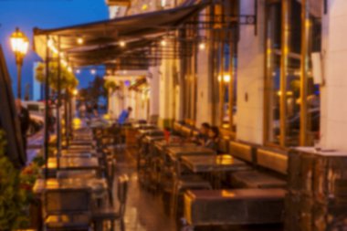 Küçük bir restoranın içi bulanık bir arka plan. Bokeh Kafe 'nin içini sıcak koyu renklerle bulanıklaştırmış. Yaratıcı moda tasarımı için arka plan olarak. Restoran, kafeterya arka planı çok güzel bulanık.