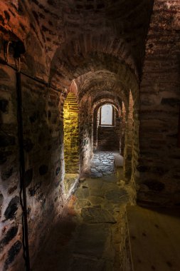 Bir dar taş merdiven bir ortaçağ kalesi eski Hıristiyan manastır Rila, Bulgaristan kulesinde. Taş duvarlı gizemli kasvetli tünel