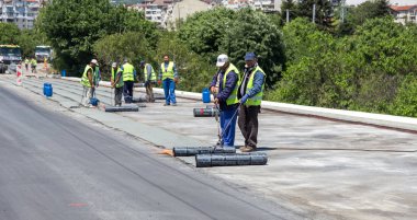 Varna, Bulgaristan - 20 Haziran 2017: yalıtım malzemesi onarım sırasında köprünün karayolu su yalıtımı, çatı kaplama, inşaat site yükler rulo, inşaat işçisi. Membran su yalıtımı kaynak sırasında alev