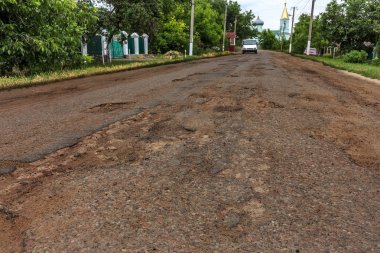Dondurma ve çözme kışın döngüsü nedeniyle çukurlar ile bozuk asfalt yol. Kötü yol.