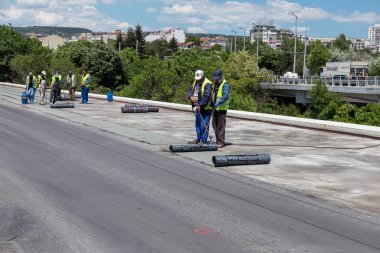 Varna, Bulgaristan - 20 Haziran 2017: yalıtım malzemesi onarım sırasında köprünün karayolu su yalıtımı, çatı kaplama, inşaat site yükler rulo, inşaat işçisi. Membran su yalıtımı kaynak sırasında alev