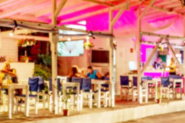 Küçük bir restoranın içi bulanık bir arka plan. Bokeh Kafe 'nin içini sıcak koyu renklerle bulanıklaştırmış. Yaratıcı moda tasarımı için arka plan olarak. Restoran, kafeterya arka planı çok güzel bulanık.