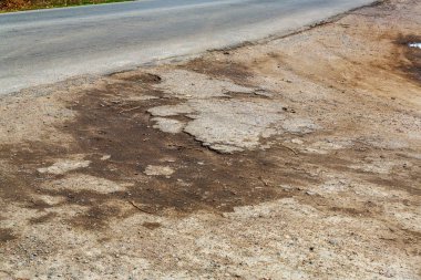 Çok kötü asfalt yol. Asfalttaki çatlaklar, çukurlar. Düşük kalitede bir yamadan sonra yerel asfalt yolunun durumu çok kötü