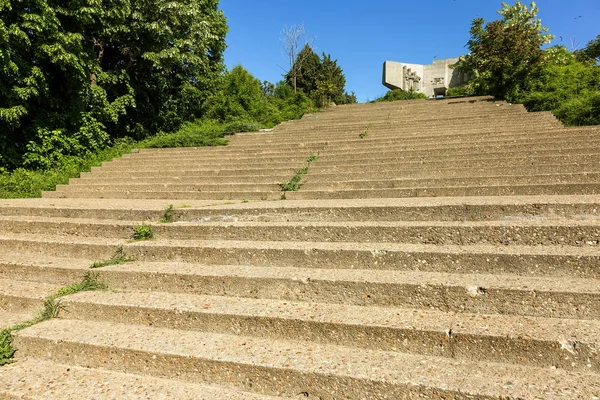 An old outdoor outdoor stone staircase. Stone, cement steps of old staircase with traces of weathering and destruction. Vintage stone staircase, ancient broken steps. Selective focus