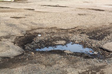 Çok kötü asfalt yol. Asfalttaki çatlaklar, çukurlar. Düşük kalitede bir yamadan sonra yerel asfalt yolunun durumu çok kötü